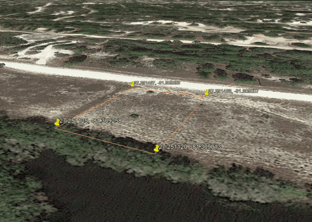 Rectangular parcel outlined in orange along a dirt road, with four corner pins and labeled coordinates.
