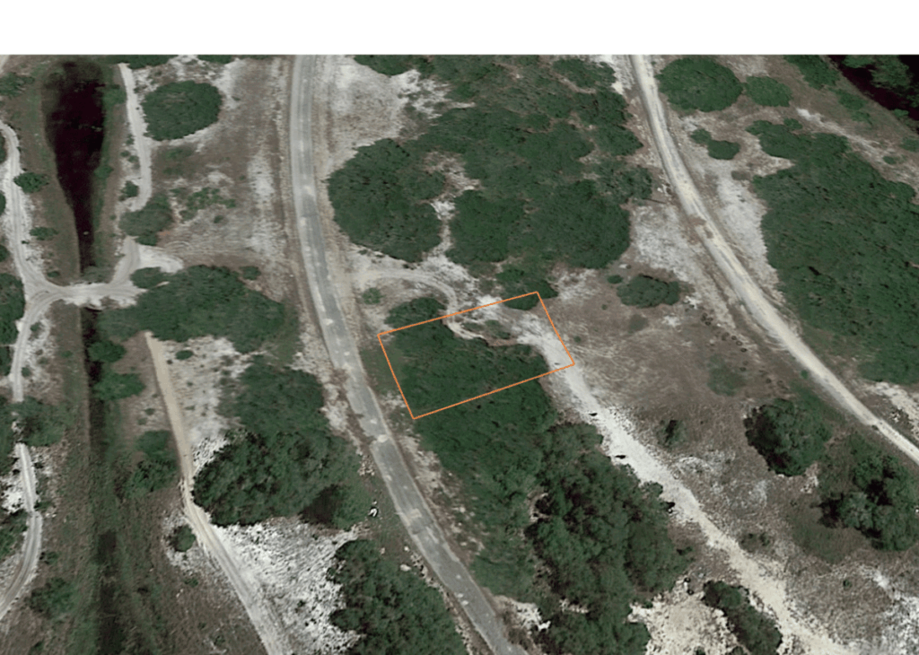 Aerial view of a hillside with a rectangular plot outlined in orange beside a winding road